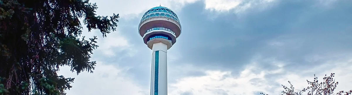 Atakule Tower in Ankara viewed from street level, revealing its observation deck and adjoining modern shopping base